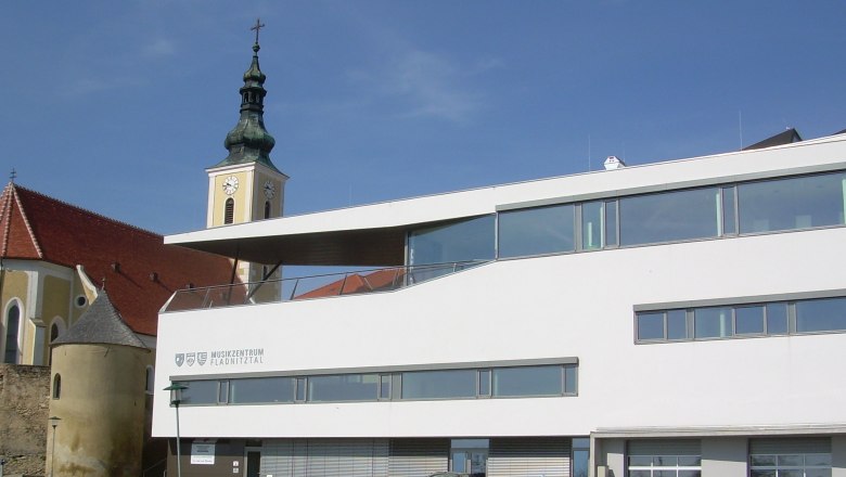 Moderne Gebäude mit Kirchturm im Hintergrund in Wölbling.