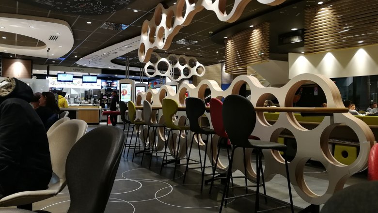 Innenansicht eines McDonald's Restaurants mit modernen Möbeln und Dekorationen.