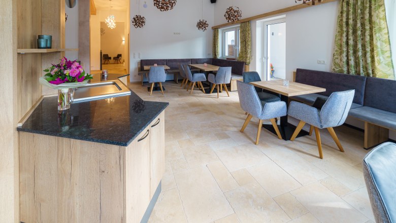 Innenansicht eines modernen Cafés mit Holzmöbeln und Blumenarrangement.