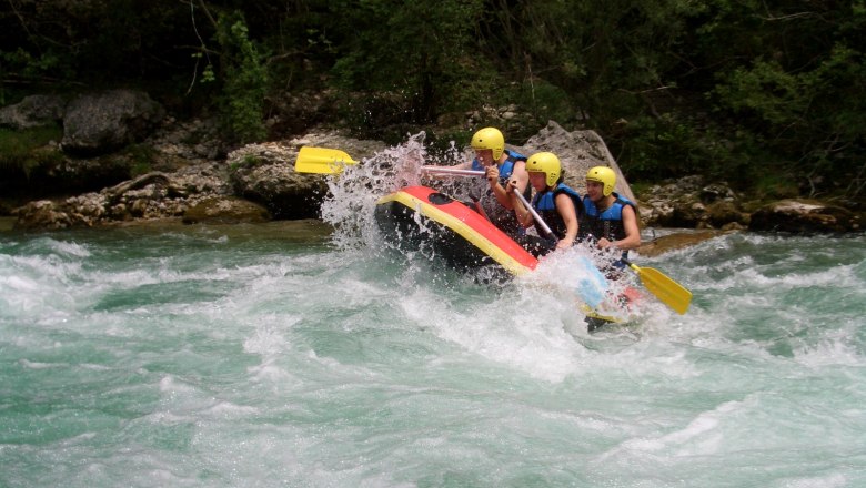 Gruppe von Menschen beim Rafting auf einem wilden Fluss.