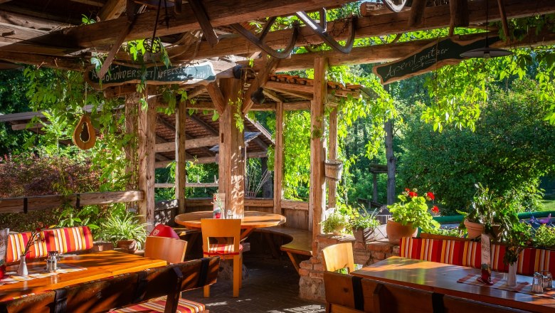 Sonniger Gastgarten im Grünen mit einladender Atmosphäre