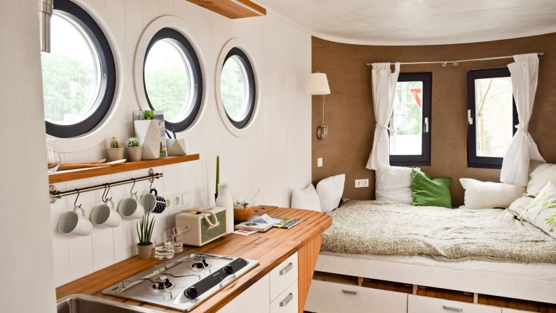 Interior view of a caravan with kitchen and bed.