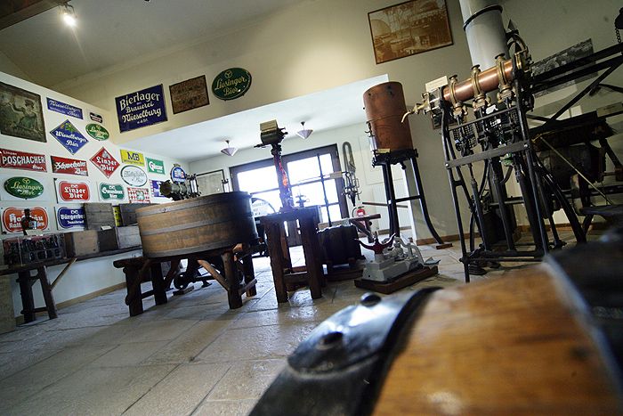 Innenansicht des Brauereimuseums Wieselburg mit alten Brauereigeräten und Schildern.