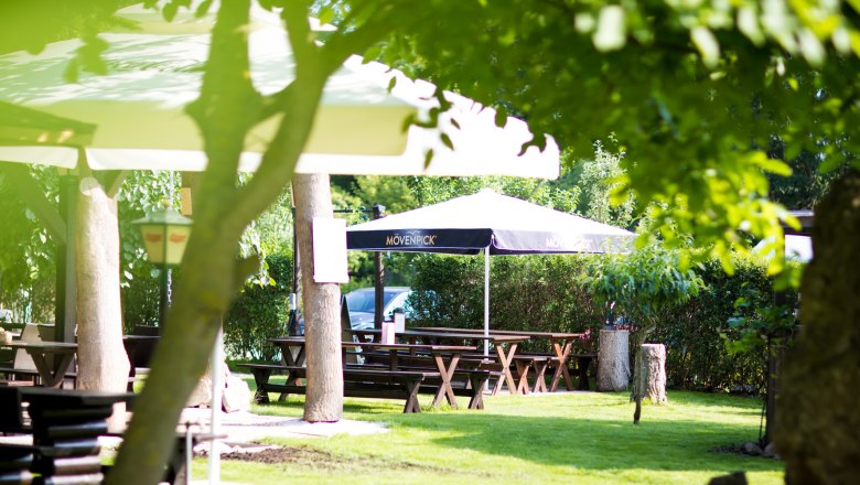 Inviting guest garden with shady umbrellas and wine tavern furniture