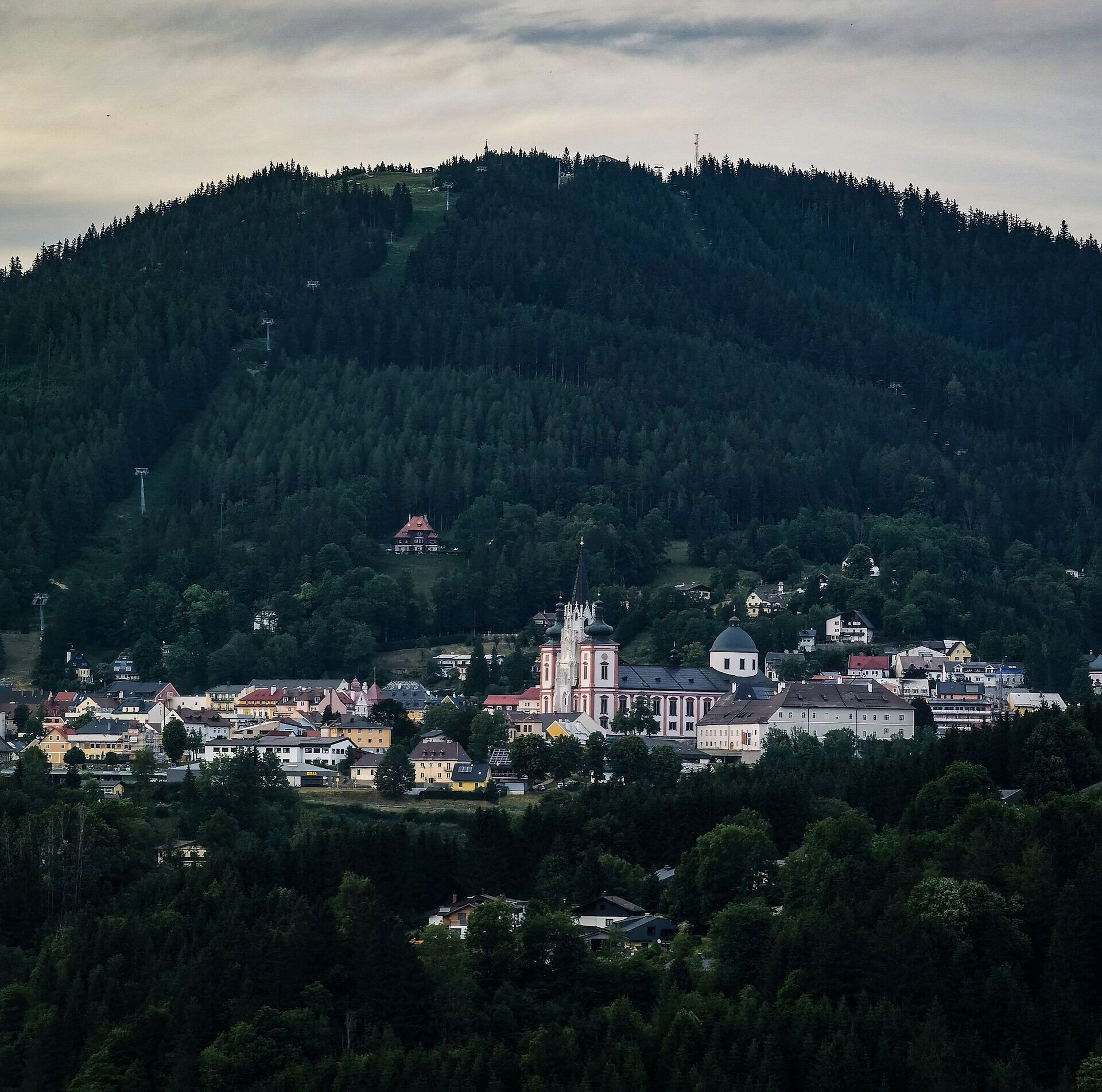 Umgeben von majestätischen Bergen und üppigen Wäldern, strahlt dieser Ort eine friedliche Atmosphäre aus. Die charmante Architektur der Gebäude harmoniert perfekt mit der atemberaubenden Natur, die hier zu jeder Jahreszeit einladend wirkt.