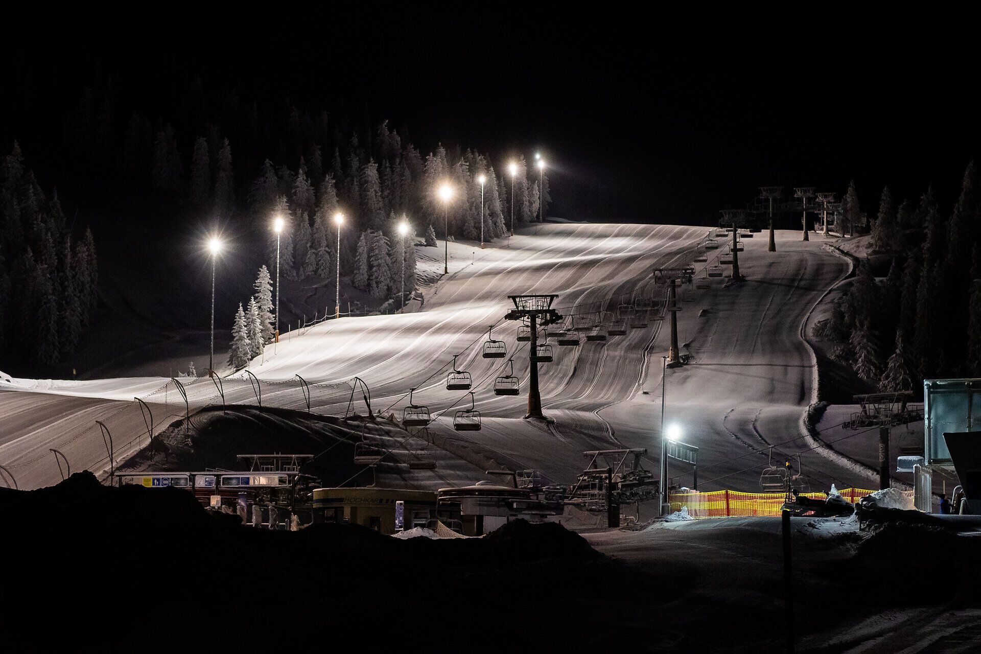 In der stillen Nacht erstrahlt die Piste unter dem sanften Licht der Flutlichtanlagen. Die schneebedeckten Hänge laden Skifahrer ein, die Abfahrten in vollen Zügen zu genießen. Ein magischer Anblick, der die winterliche Schönheit der Ybbstaler Alpen perfekt einfängt.