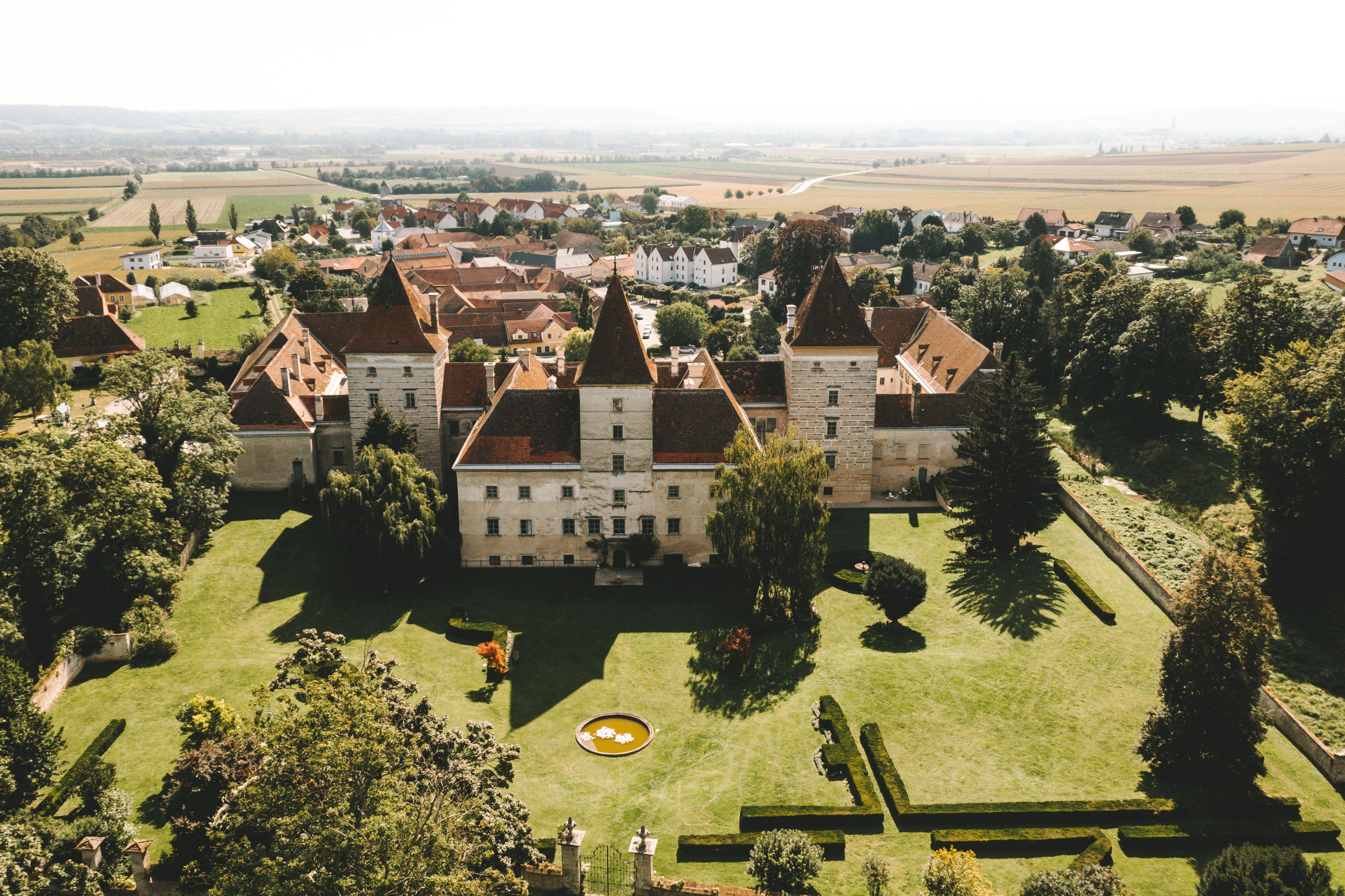 Luftaufnahme von Schloss Walpersdorf mit umliegender Landschaft.