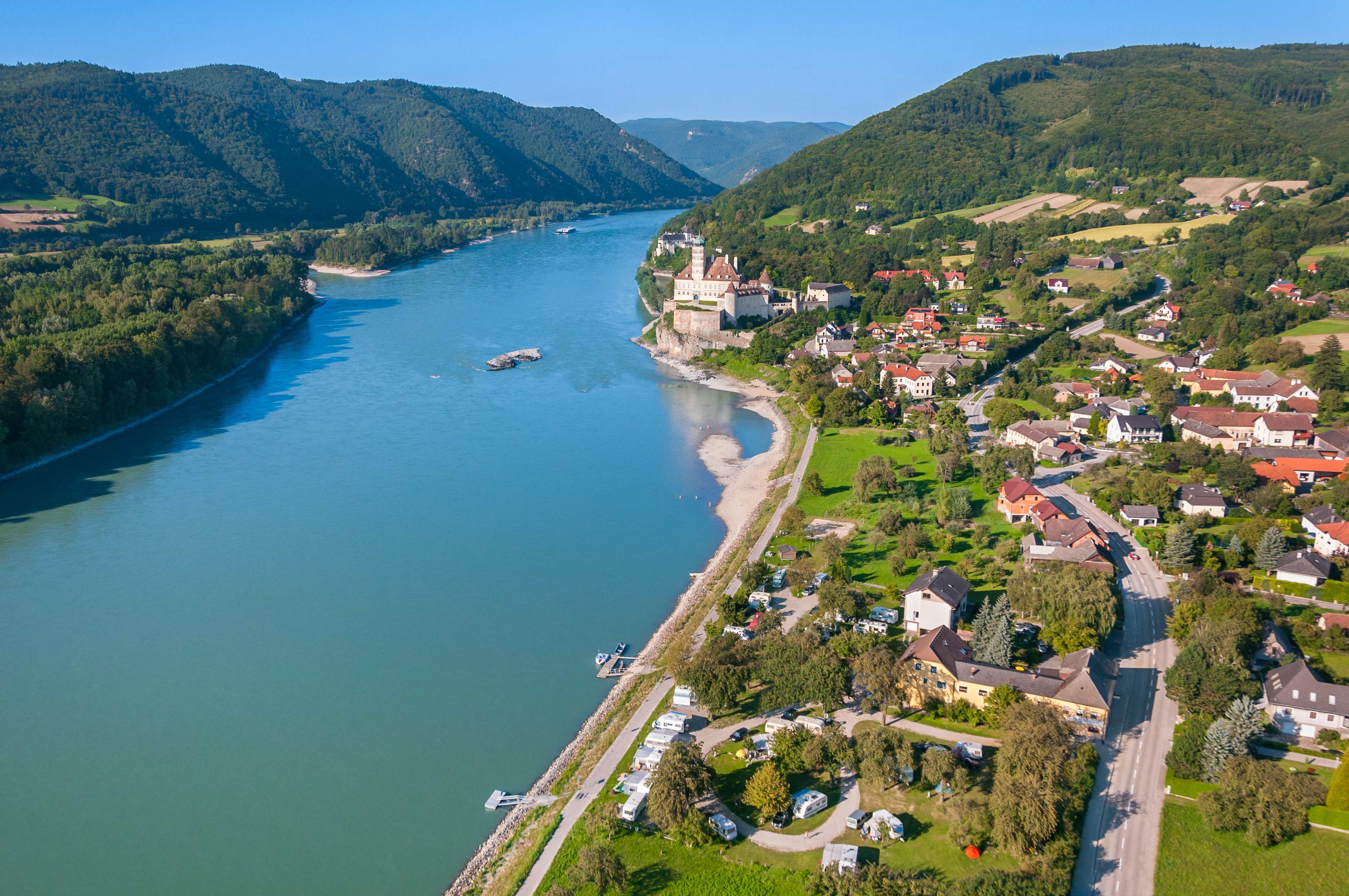 Luftaufnahme von Schönbühel-Aggsbach an der Donau mit Schloss und umliegender Landschaft.