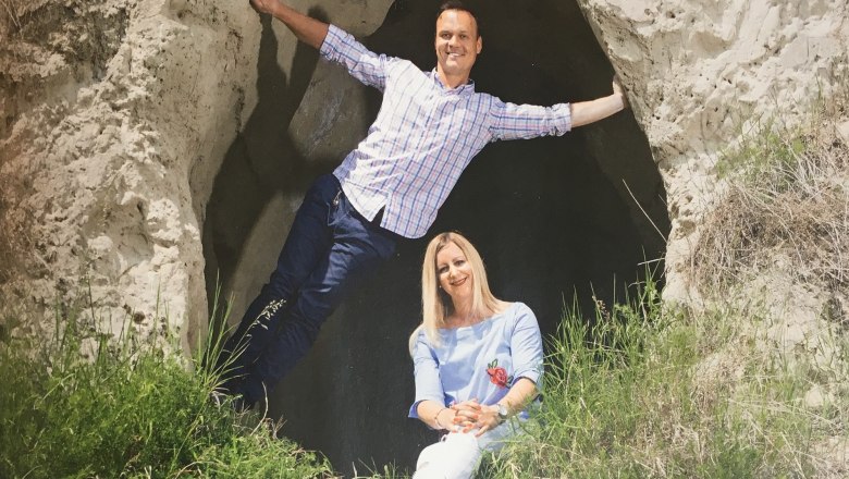 Zwei Personen posieren vor einer Felsenh&ouml;hle.