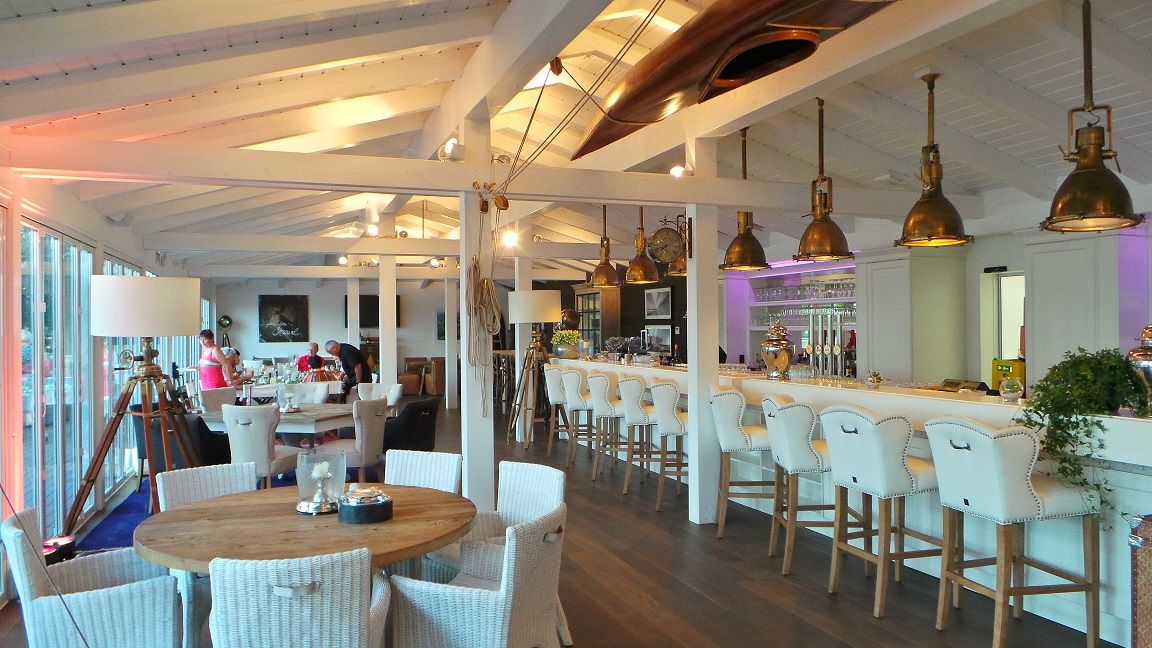 Innenansicht eines stilvollen Frühstücksrestaurants mit Bar und Sitzbereichen.