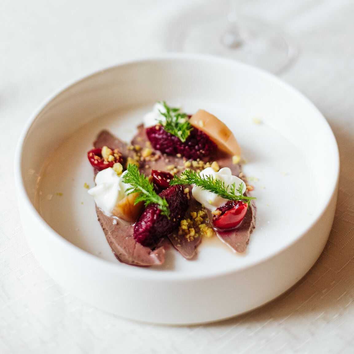 Ein köstliches Dessert, kunstvoll angerichtet, verführt mit frischen Beeren und einer cremigen Note. Die harmonische Kombination aus Aromen und Farben lädt dazu ein, den Moment zu genießen und die Schönheit der Umgebung zu erleben.