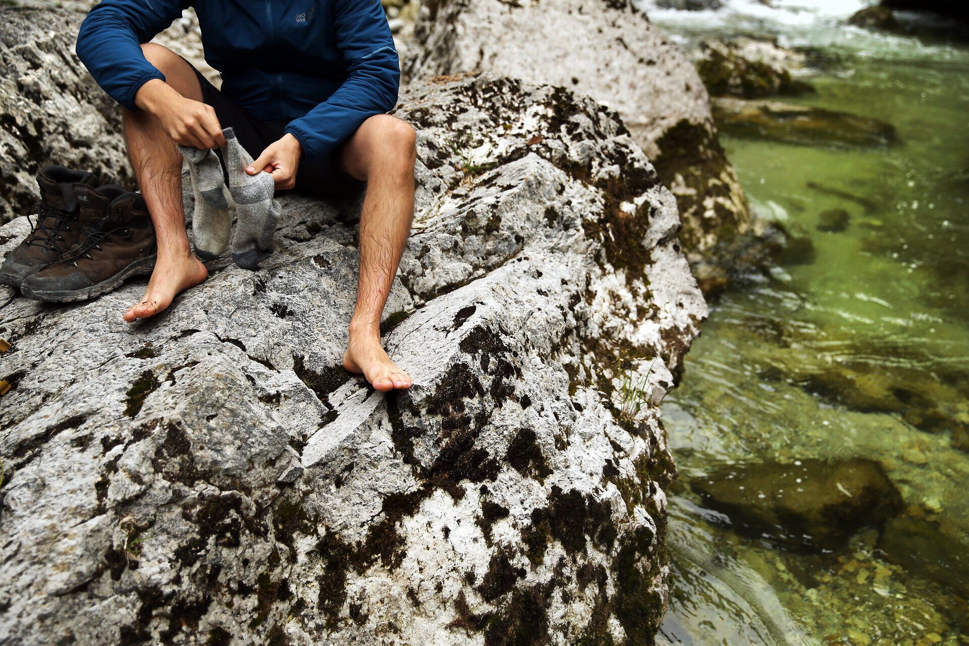 An einem klaren Sommertag entspannen Wanderer am Ufer eines glitzernden Baches, während sie ihre Füße im kühlen Wasser baumeln lassen. Die umliegenden Felsen sind mit moosbedeckten Pflanzen geschmückt, die die natürliche Schönheit der Region unterstreichen. Hier, in der Stille der Natur, wird jeder Moment zu einem unvergesslichen Erlebnis.