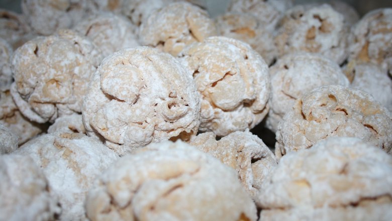 Nahaufnahme von mit Puderzucker best&auml;ubten Geb&auml;ckkugeln.