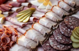 Verschiedene Wurst- und Fleischsorten auf einem Teller angerichtet.