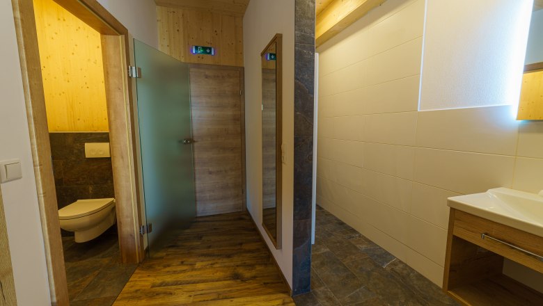 Modernes Badezimmer mit Holzelementen und Glasdetails.